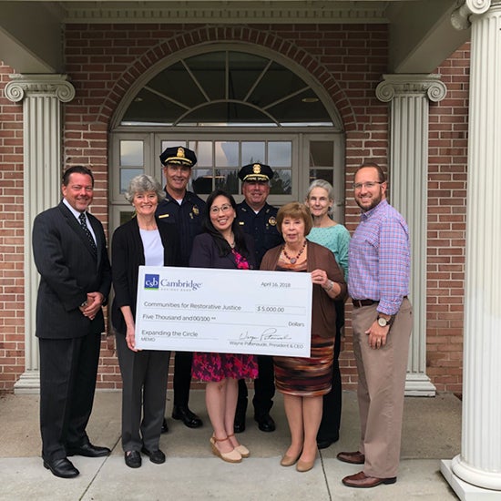 Representatives from Communities for Restorative Justice and CSB posing with large check