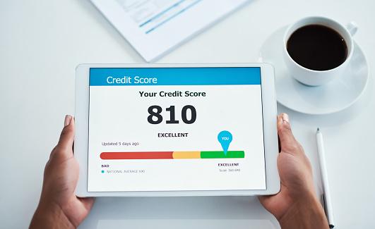 2 hands holding a tablet that is displaying a credit score of 810