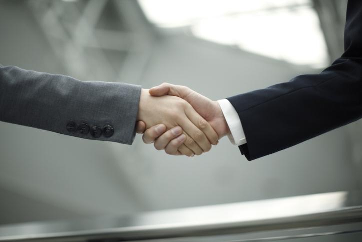 Two people in suits shaking hands